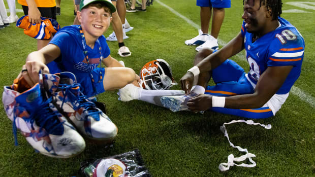 Florida Gators fan holds up autographed cleats.